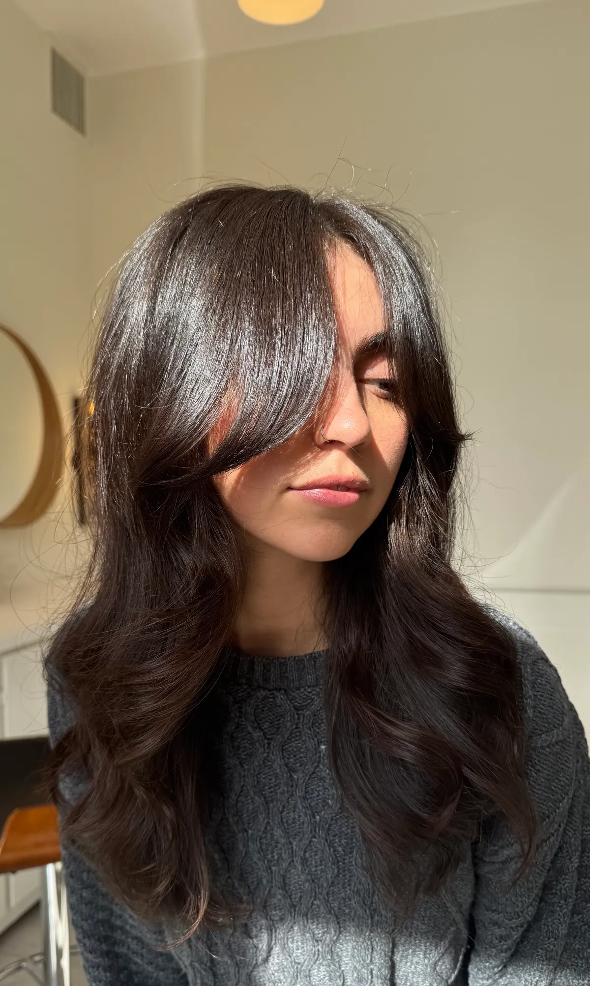 Dark brunette long layers with curtain bangs, finished to a high gloss shine.